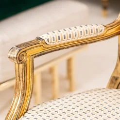 Poltrona dorata a motivi in stile Luigi XVI