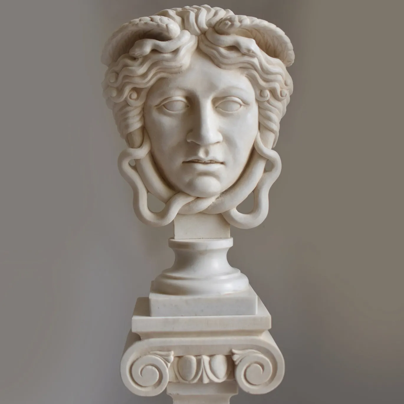 Scultura Medusa in marmo bianco di Carrara su trapezoforo