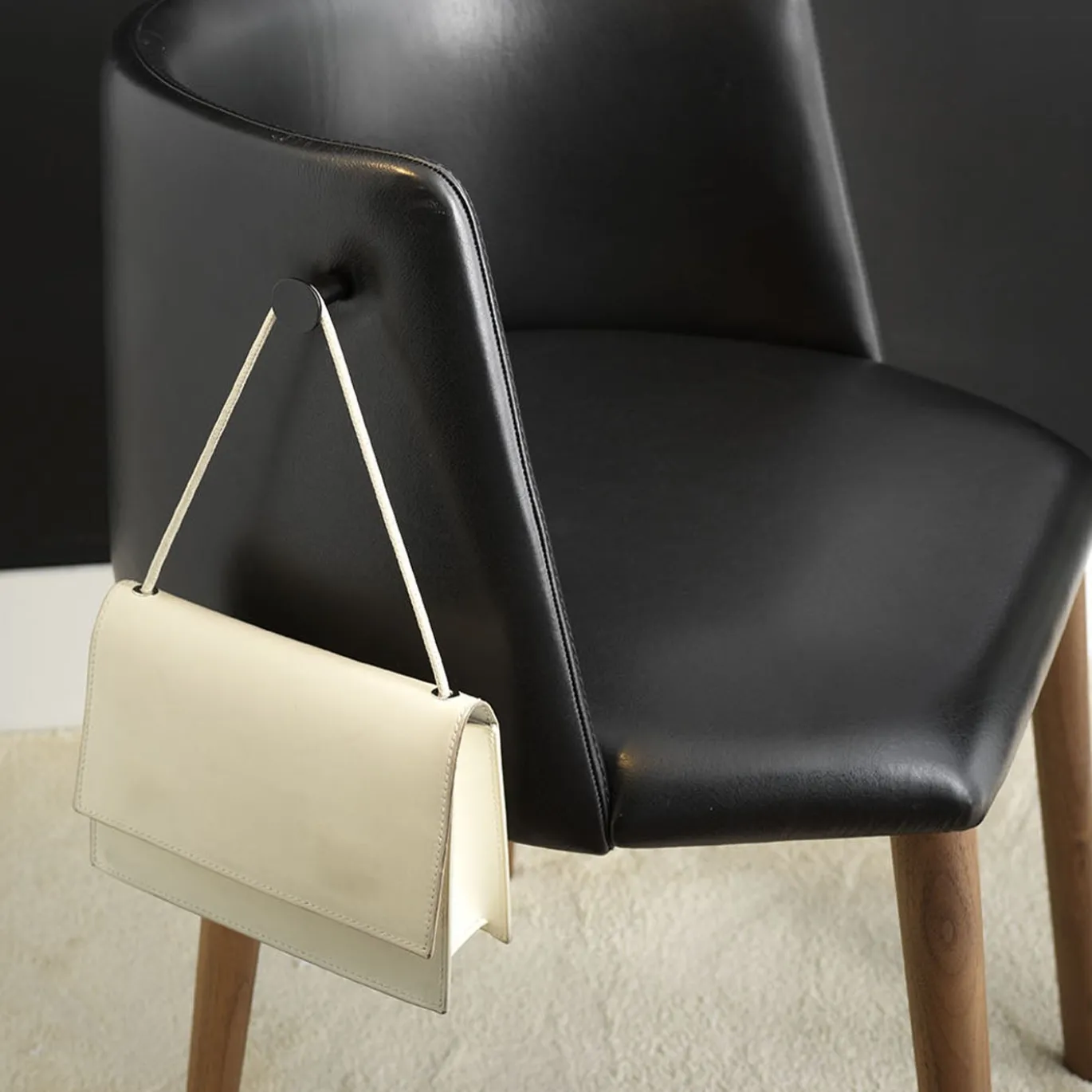 Sedia Pergy in pelle nera con gambe in noce