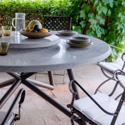 Tavolo da pranzo outdoor rotondo Hermu 150 in pietra peperino grigia e acciaio marrone