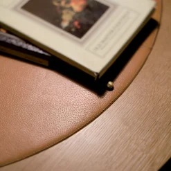 Tavolo da pranzo rotondo con piano in pelle di Michele Bonan